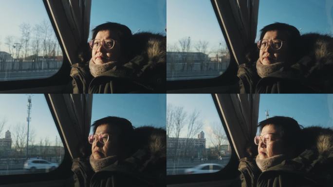 一名亚裔中国妇女坐在公交车里看着窗外