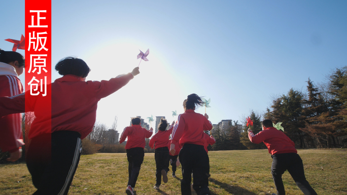 孩子手拿风车奔跑 小学生手拿风车草地奔跑