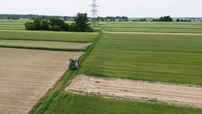 无人机领域的劳动:拖拉机驾驶通过耕地在日光下