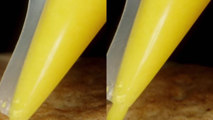 用包里的黄糖霜盖在姜饼上装饰。多莉滑块，近一点。