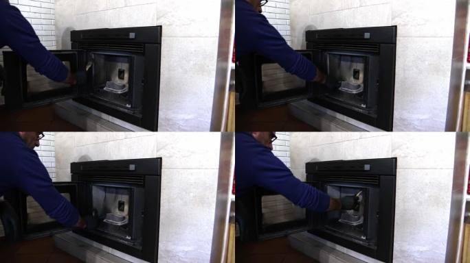 一名男子用刷子清洁肮脏的颗粒炉。