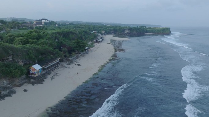 无人机在印度尼西亚巴厘岛乌鲁瓦图的热带巴兰干海滩上空飞行，海浪破碎