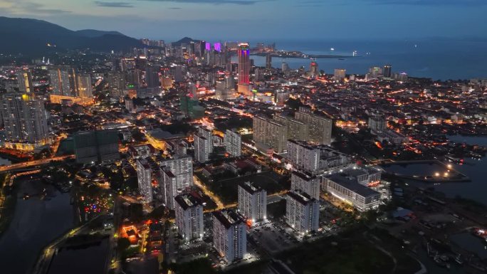 马来西亚槟城乔治城的城市灯光。在日落之后飞越槟城乔治城的摩天大楼和大街