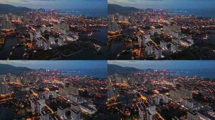马来西亚槟城乔治城的城市灯光。在日落之后飞越槟城乔治城的摩天大楼和大街