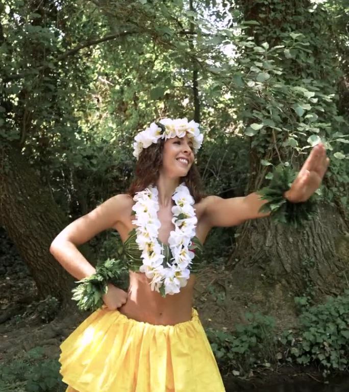 一位年轻女子带着美丽的微笑在河中跳着传统的夏威夷舞蹈。