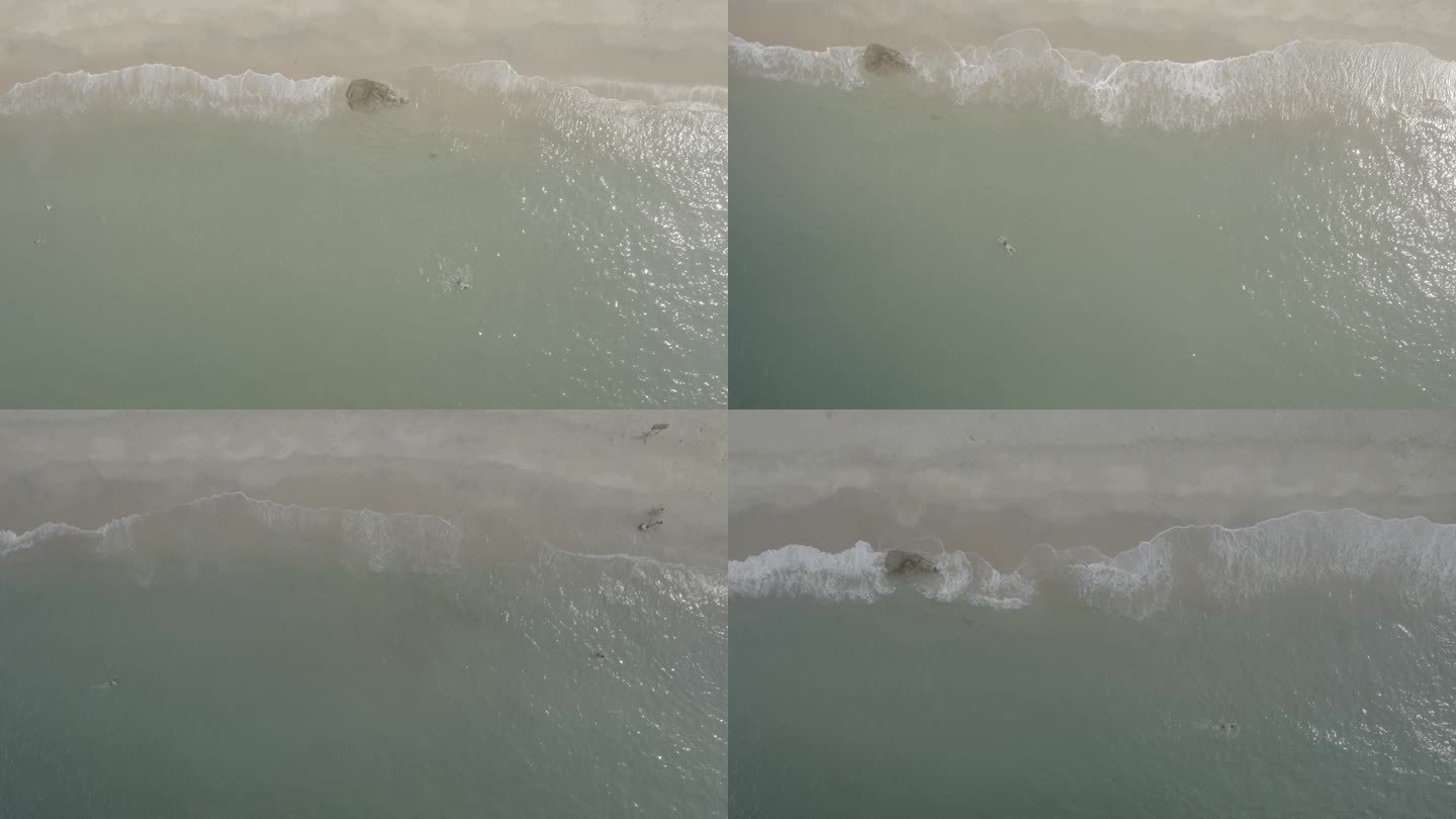 航拍俯视汹涌的浪花拍打沙滩