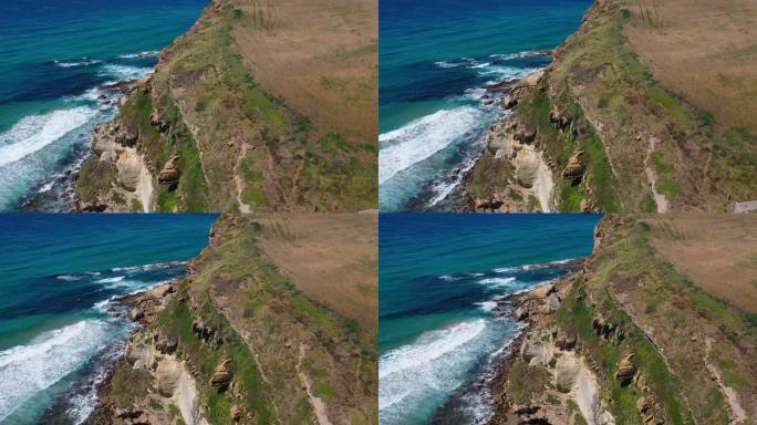 在西班牙坎塔布里亚，从海上的悬崖上俯瞰，留下一片草地，海浪拍打着岩石，想象着不同层次的石头和不同深浅