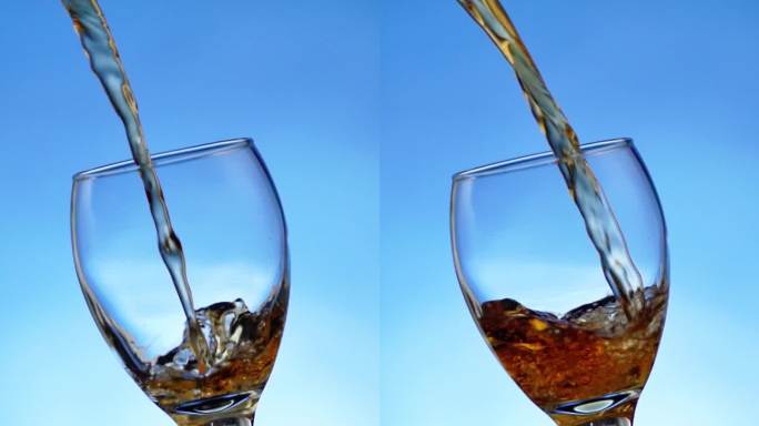 蓝色背景中玻璃杯中倒入威士忌洋酒