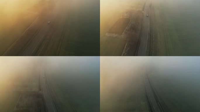 鸟瞰图:汽车在绿色的田野上滑行，被柔和的雾包围