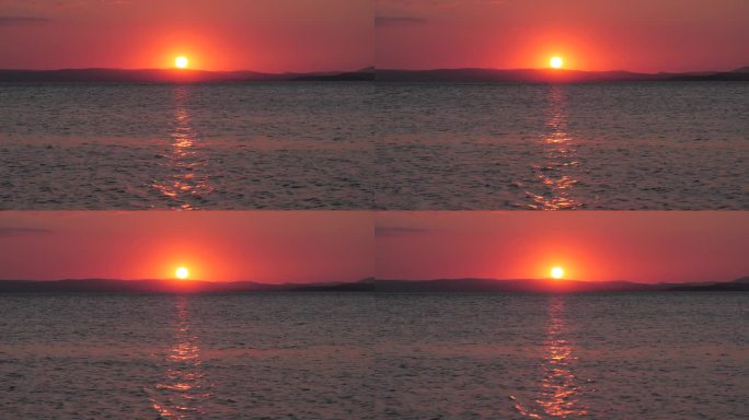 4K:海上金色的夕阳。英格兰兰开夏郡的莫克姆湾面向湖区山丘。库存视频剪辑镜头。