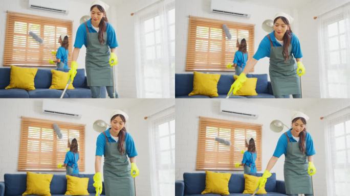 亚洲女佣或管家团队帮助打扫客厅，一人用扫帚清洁地板，另一人用鸡毛掸子清洁窗户。