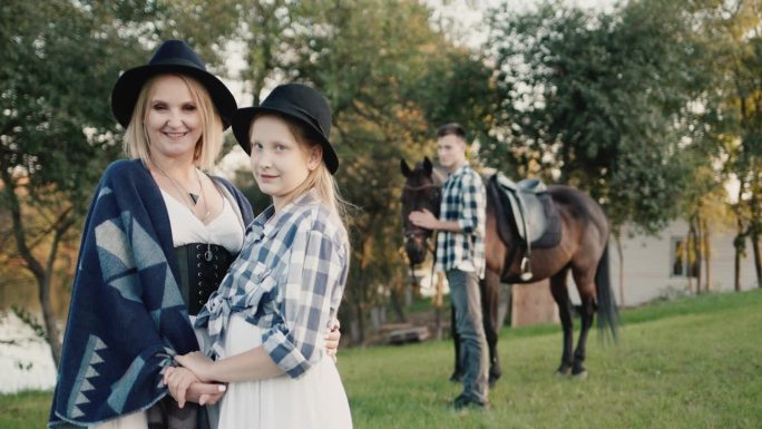 妈妈带着女儿和一个带马的年轻人一起出游计划——拍摄带马和绿色旅游的照片