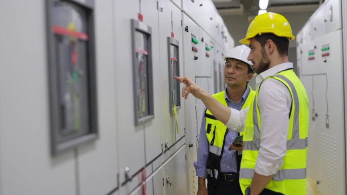 4K男工程师在工厂服务器电控室团队工作。