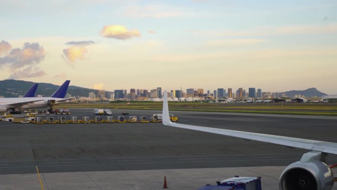 日落时分，飞机在机场滑行，檀香山的城市天际线，4k慢动作，60fps