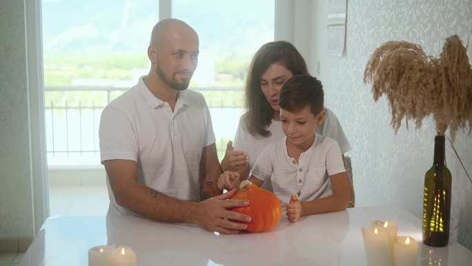 爸爸、妈妈和儿子用南瓜雕刻万圣节灯笼