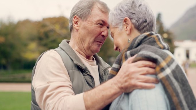 亲吻，额头和长辈夫妇在公园里用爱，快乐和谈话用浪漫的纽带。接吻，老人和老人拥抱女人的关怀，浪漫或灵魂