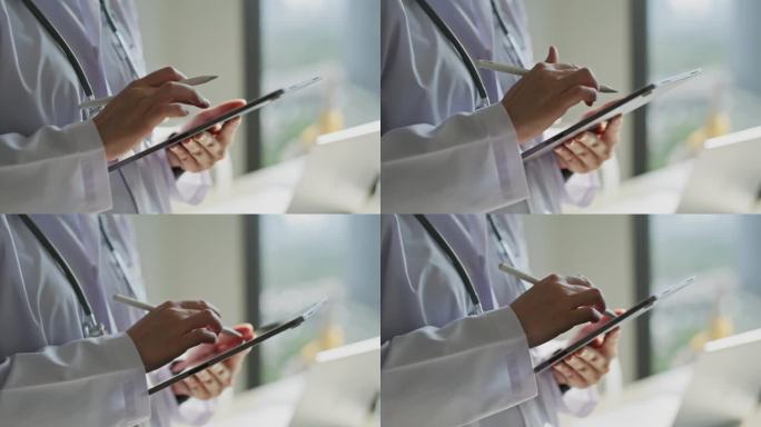在现代医院工作的医生手持和使用数字平板电脑