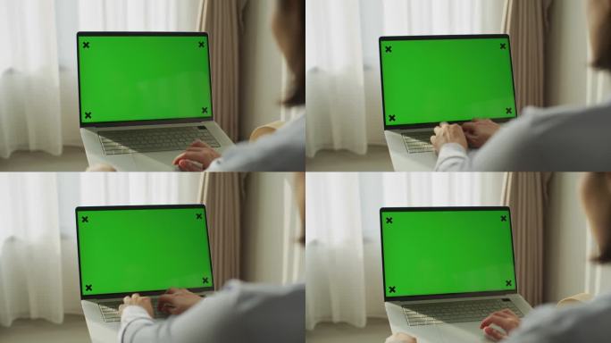 亚洲女人用绿屏笔记本电脑