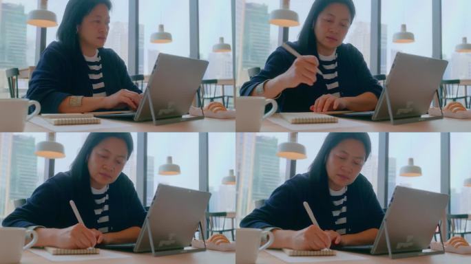 亚洲人在咖啡厅用笔记本电脑远程工作时，在数据表中写想法