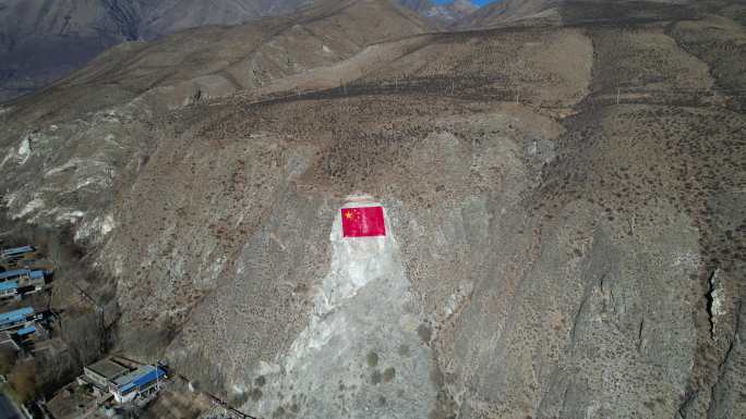 西藏村落旁石壁上的国旗