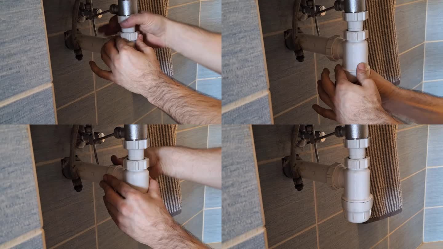 水管工在修理污水的隔臭器。一个男人的手在浴室的洗脸盆下面固定装置。然后水开始从泄漏的废物收集器中泄漏