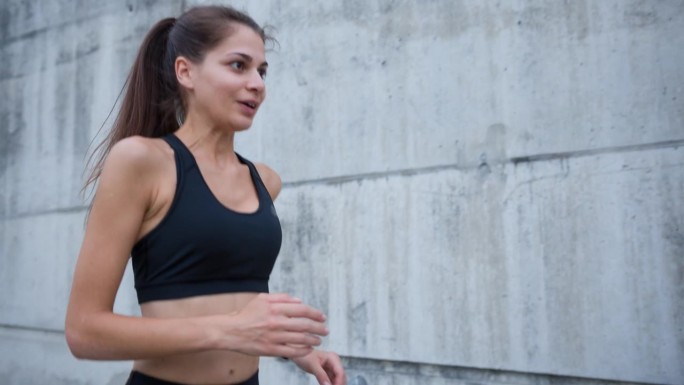 女性跑步者在爬完楼梯、进行户外锻炼后，用智能手表检查自己的速度