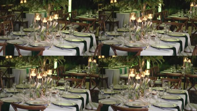 餐桌上装饰着自然的树叶，蜡烛和玻璃器皿的婚宴。