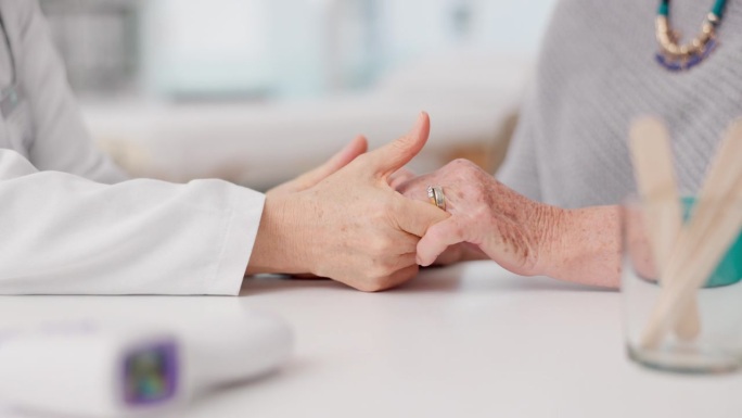 老年妇女、医生和病人手牵着手在医院照顾老人、关爱或咨询。医疗专业人员为医疗信任、支持或预约而触摸手的
