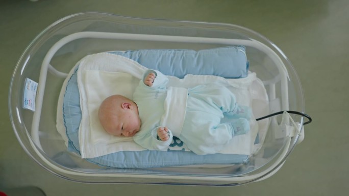 小哈欠:刚出生的男婴在产科病房的婴儿床里找到了安宁