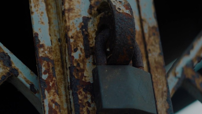 生锈的铁门用一把旧锁锁着