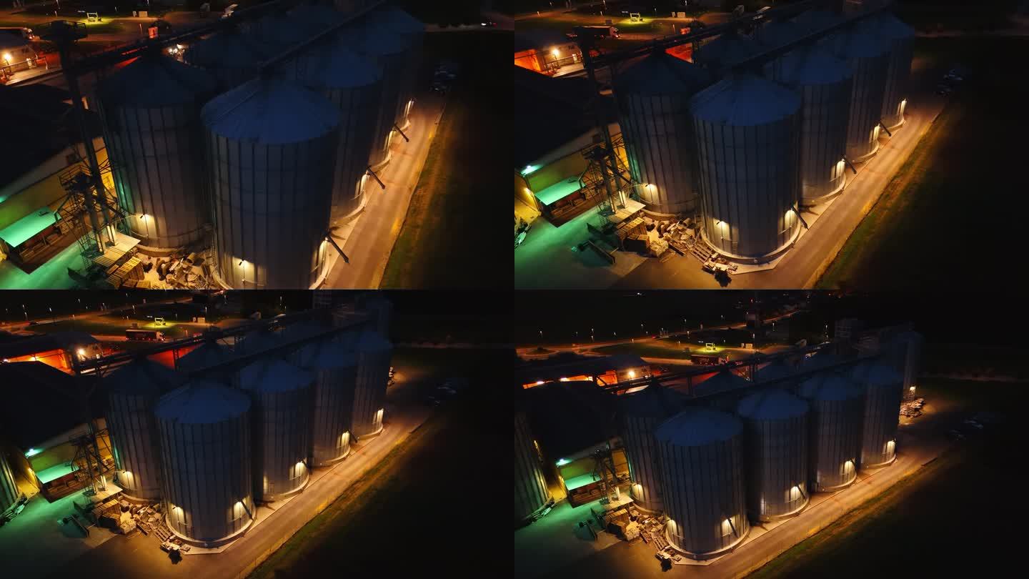 无人机在夜晚拍摄黑暗农场的照明筒仓