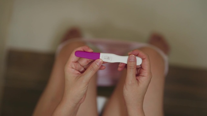 浴室里女性的手怀孕测试呈阳性