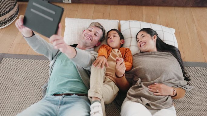 快乐的家庭，平板电脑和躺在地板上自拍，照片或照片放松一起在家里的客厅。父亲，孩子和母亲在科技和微笑中