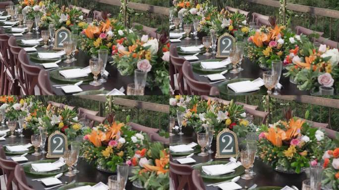 婚礼宴会桌与五颜六色的花卉中心。餐桌上摆放着精美精致的玻璃餐具。