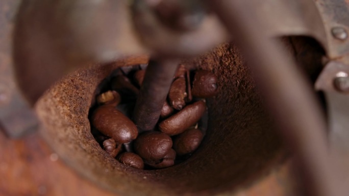 老式咖啡研磨机旋转和研磨烘焙咖啡豆