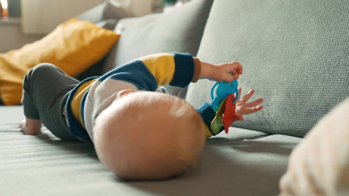 小男孩躺在沙发上玩玩具