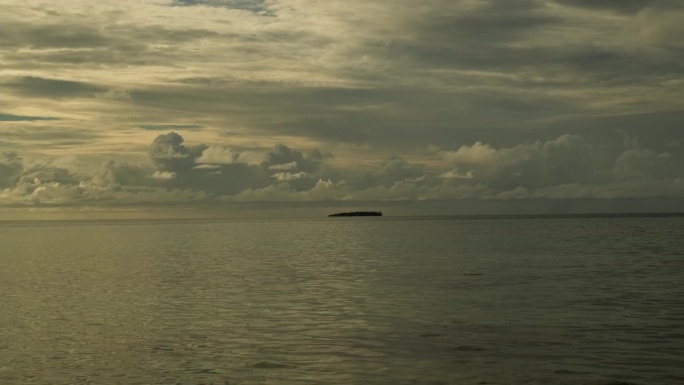 日落时平静的海浪。美丽的暴风雨前多云的天空为背景。