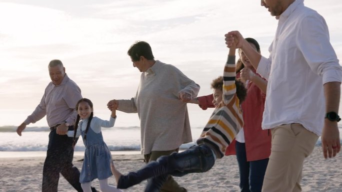 海滩，孩子和幸福的家庭手牵着手，在日落时度假或冒险。男人，女人或父母和祖父母与孩子一起在海边散步，寻