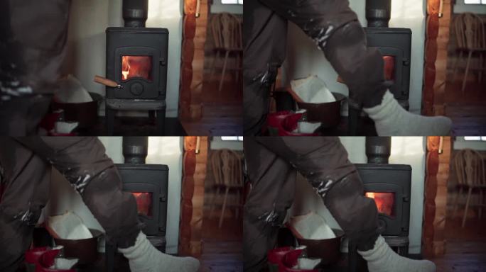 在挪威特隆德拉格郡的贝萨克，一名男子正在暖炉前晒腿——特写