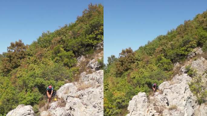 戴着红色安全帽的攀登者在岩石顶部准备攀爬绳，准备下山。