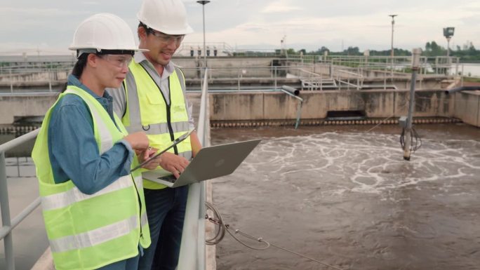两名环境工程师在污水处理厂工作，水管理概念。