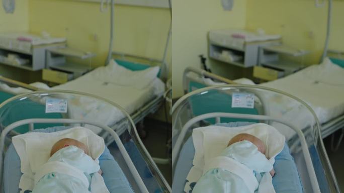 慢镜头垂直镜头新的开始:介绍新生儿在医院婴儿床在产科病房