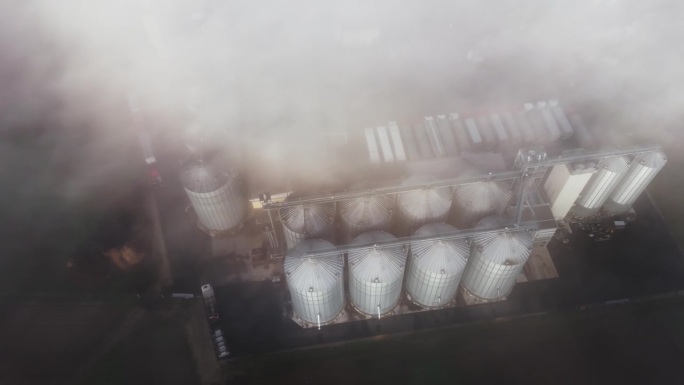 无人机在乡村清晨农场的筒仓上拍摄雾