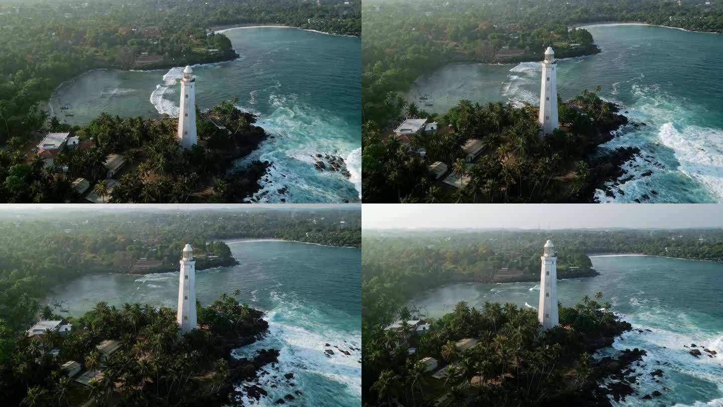 无人机灯塔在多岩石点在东德拉头，斯里兰卡。海浪冲击着被绿色植物包围的悬崖。历史灯塔巍然屹立，指引着水