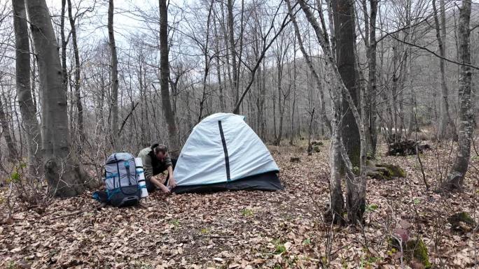 一个人在森林里独自搭起了露营帐篷。帐篷股份。