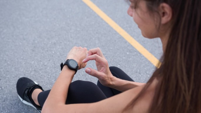 女运动员在锻炼后查看她的智能手表上的进度