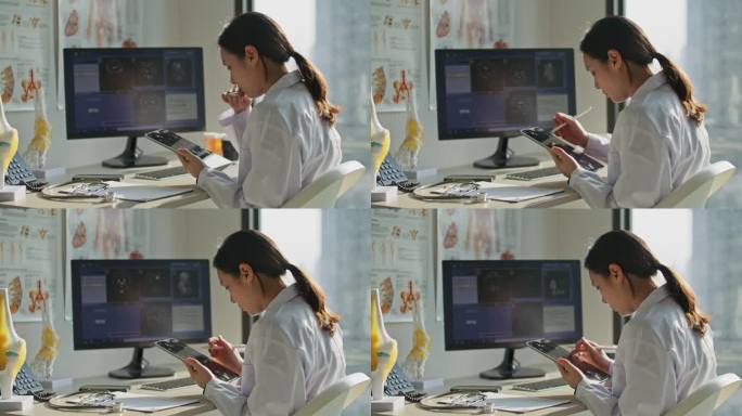 医生在医院的办公桌上使用数码平板电脑分析x光胶片扫描