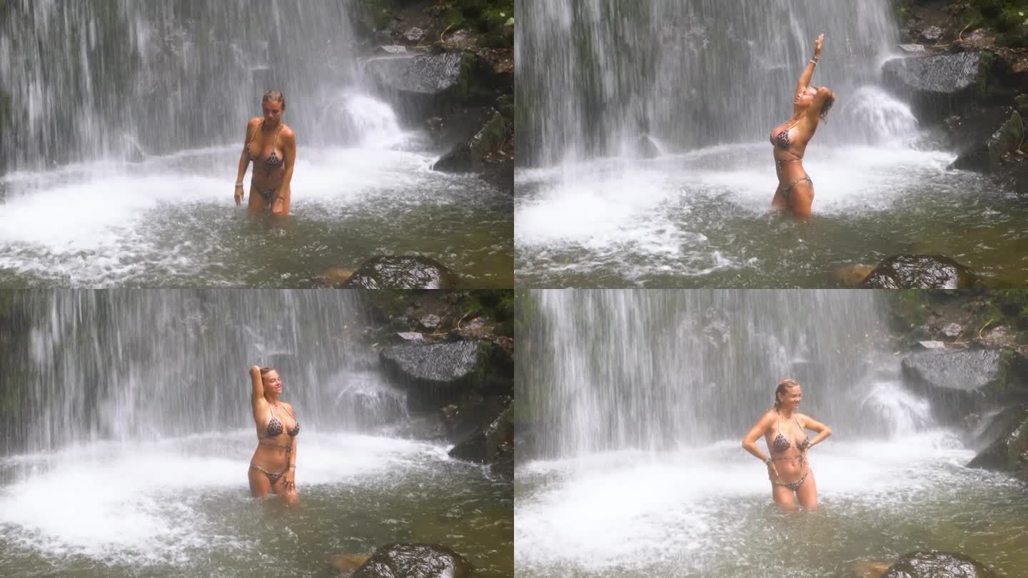 一个女孩在山间湖泊的瀑布下洗澡。
