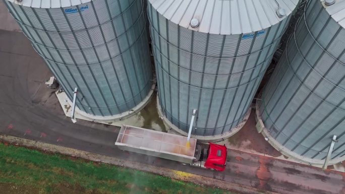 无人机在农场拍摄筒仓填充拖车卡车