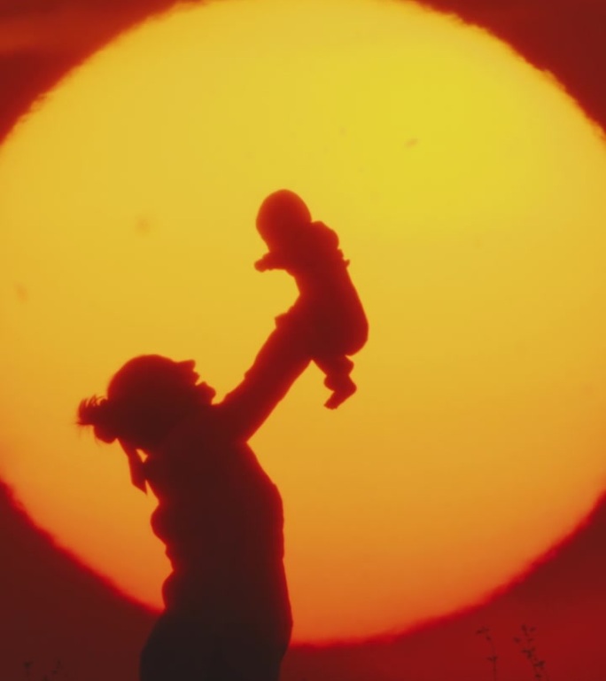 《黄昏的拥抱:草地的黄金时刻》中母亲温柔的举起和亲吻婴儿